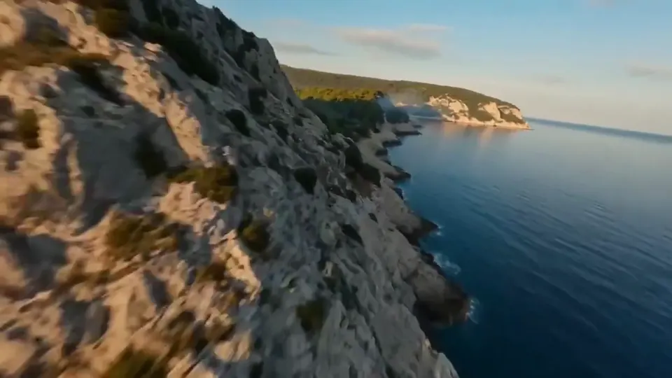 A rocky coastline beside blue water, a scene idea for extending a travel shot