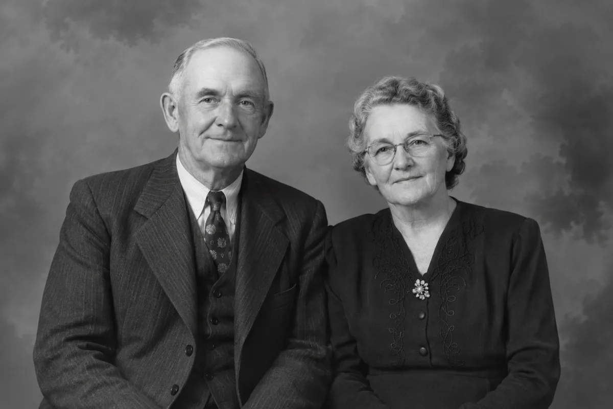 Restored black-and-white studio portrait of a fictional older couple